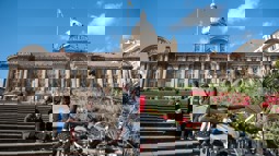 A group of people sit outside Birmingham Council building on a sunny day