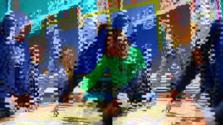 A Walk Wheel Cycle Trust member of staff talks with children at a street design workshop at Acasias Primary School 