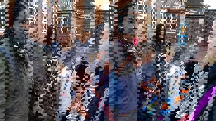 A family talking to a Walk Wheel Cycle Trust officer outside school