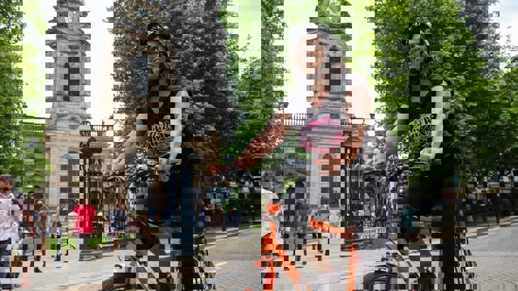 Lady casually cycling in the city with helmet