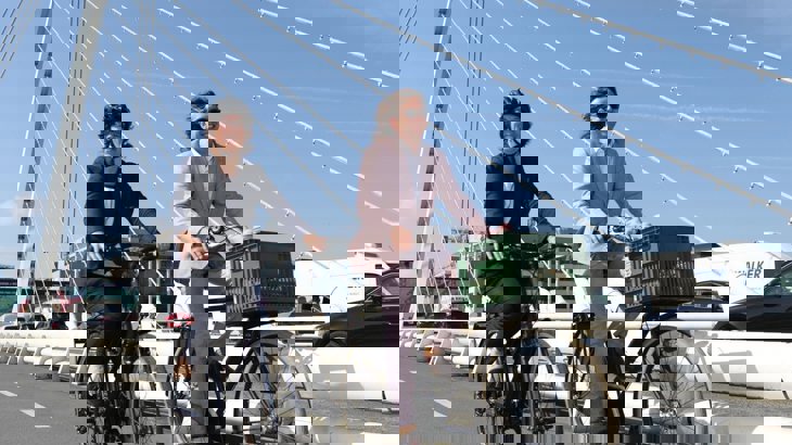 Anne Graham CEO National Transport Authority and Xavier Bryce CEO Walk Wheel Cycle Trust cycling on two bikes across bridge in Dublin 