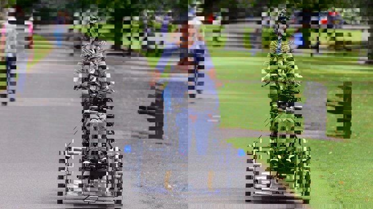 Mum and child cycling through park on an adapted trailer bike