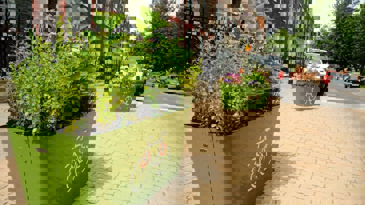 Two planters with flowers and plants on a traffic-free space in a residential street