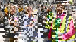 staff member dianne at an information stand with two women holding cycling literature at cycle to work day event outside in Belfast City Centre