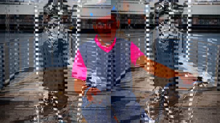 Man wearing sunglasses and a cycle helmet, sitting on his tricycle smiling and laughing.