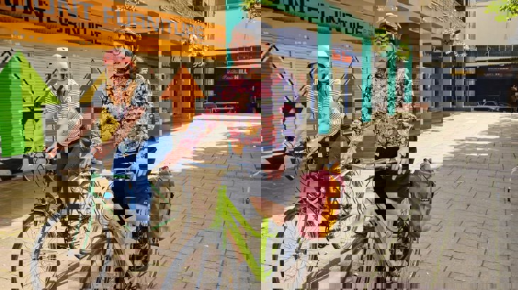 Two Women Cycling On Bikes In Urban Area