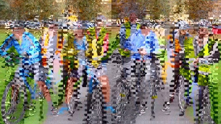 group of cyclists in high vis vests in park