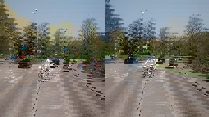 cyclists waiting to cross road at busy junction