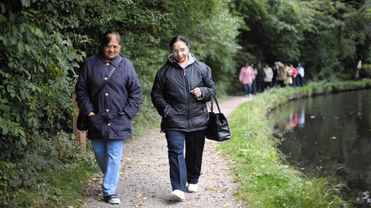 Two older ladies chatting together as they walk along a canal-side traffic-free path.