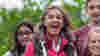 Close-up photo of a group of teenagers laughing and smiling at the camera.