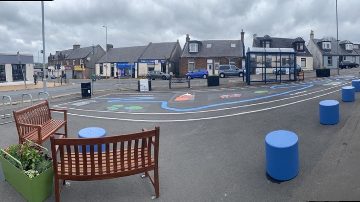 Benches, planters and artwork on the ground in Hurlford, part of a pop-up parklet.