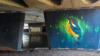 A tunnel with vibrant artwork of a bird