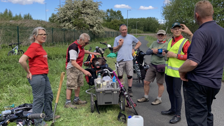 a group of volunteers with their tools standing along an NCN path