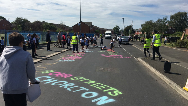School street outside with many children and chalk on road