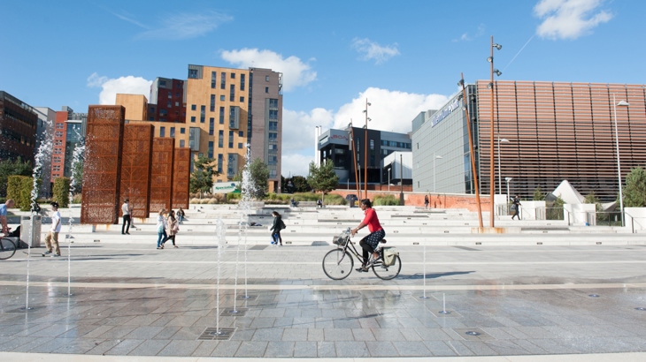 People walking and cycling through Eastside City Park, Birmingham