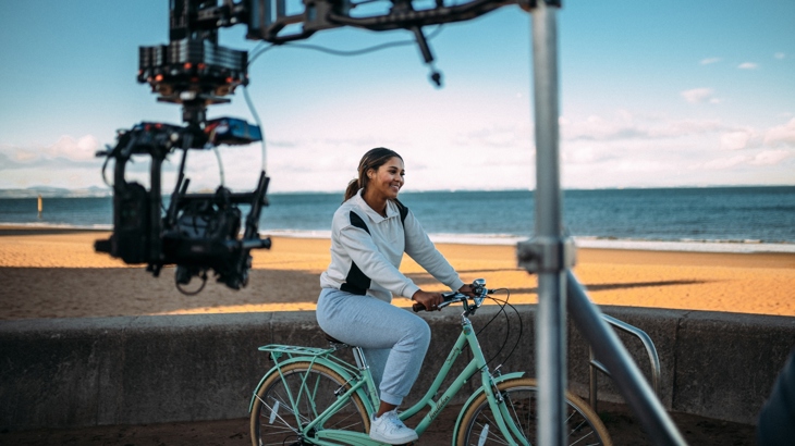A teenage girl is filmed at the sea shore as part of the #AndSheCycles campaign.