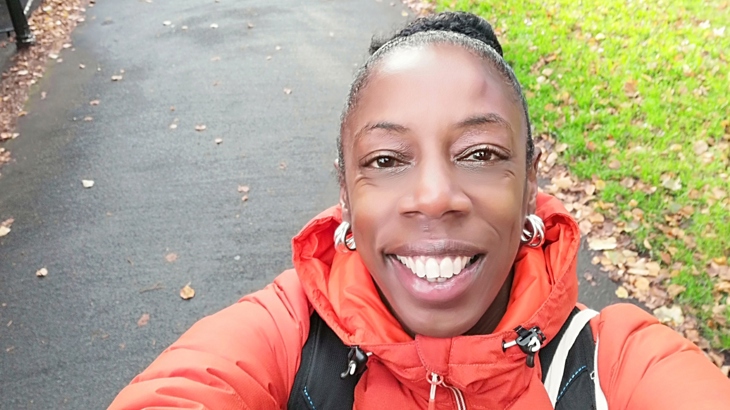 Sophie Brown of Steppin Sistas smiles for a selfie whilst walking a path.