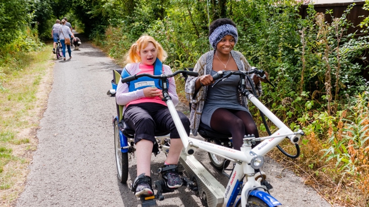 Two people using an adapted cycle on the Bristol and Bath Railway Path -