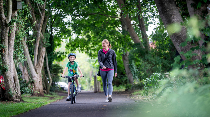 Mother and child out for a morning stroll/cycle.