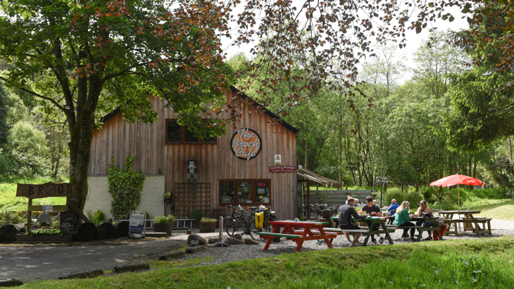 The Broch cafe in Perthshire on a sunny day with benches and bikes outside and people enjoying a cuppa.