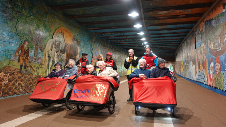 Three trishaws with smiling passengers inside Alloway Railway Tunnel; enjoying a bike ride to see the art mural in the tunnel.