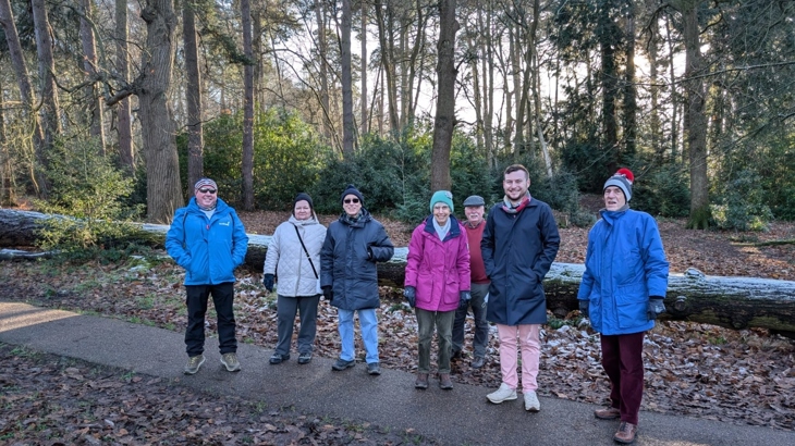 A group of people walk in a frosty woodland
