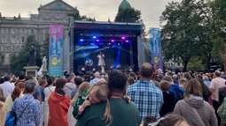 Crowds stand watching stage for Irish Music Festival, the Fleadh, outside Belfast City Hall