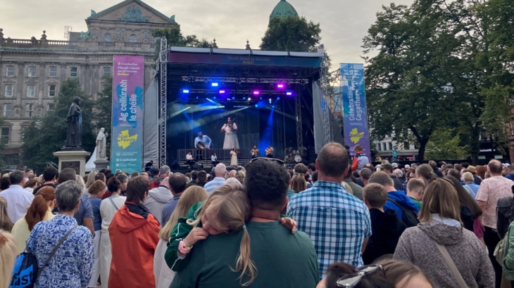 Crowds stand watching stage for Irish Music Festival, the Fleadh, outside Belfast City Hall