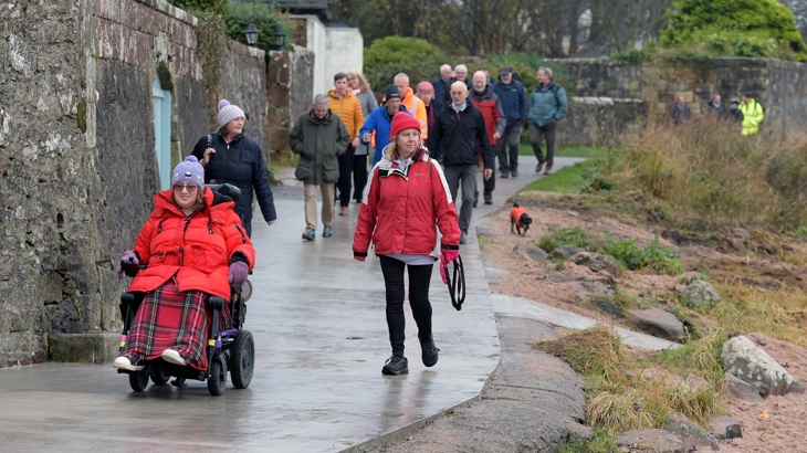 Members of the community, partners and elected officials come together to celebrate the opening of the Fairlie Coastal Path. They walk and wheel along the new route on the waterfront.