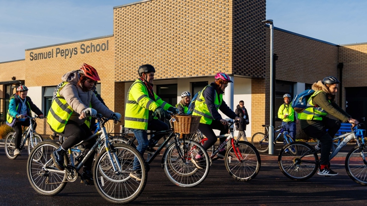 A group of pupils cycle past Samuel Pepys School in St Neots with Mayor Dr Nik Johnson