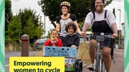 Two women cycling on segregated path with two young children in cargo bike in front