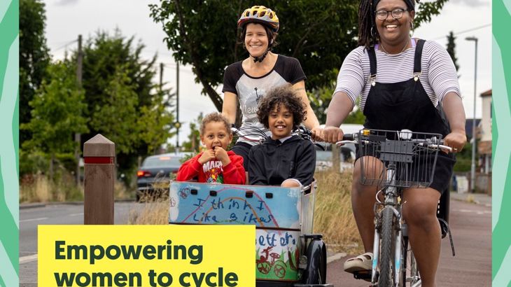 Two women cycling on segregated path with two young children in cargo bike in front