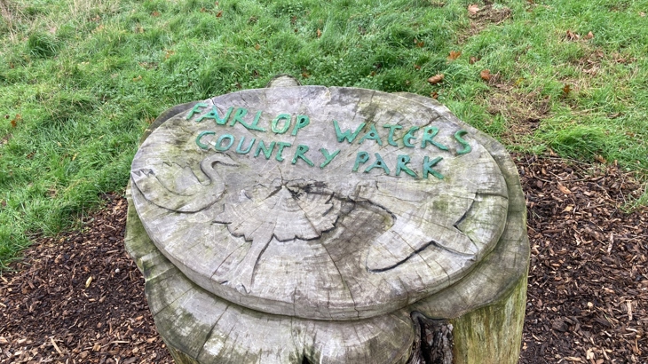 A carved sign on a log in Fairlop Waters