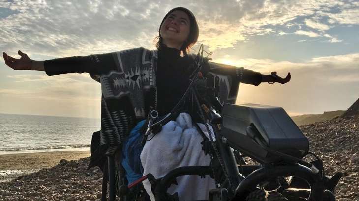 a woman with a handcycle on a beach
